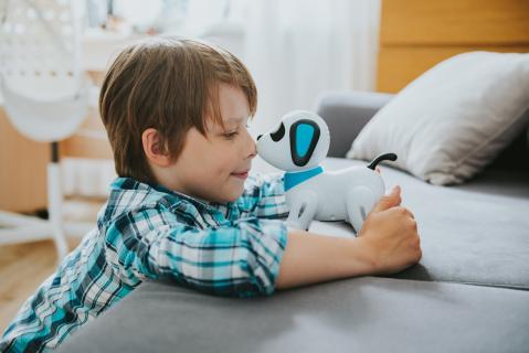 Smartes Spielzeug: Kind mit Roboterhund