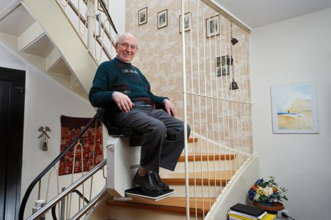 Älterer Herr auf Treppenlift