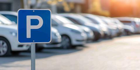 Parkplatzschild im Vordergrund im Hintergrund Autos verschwommen
