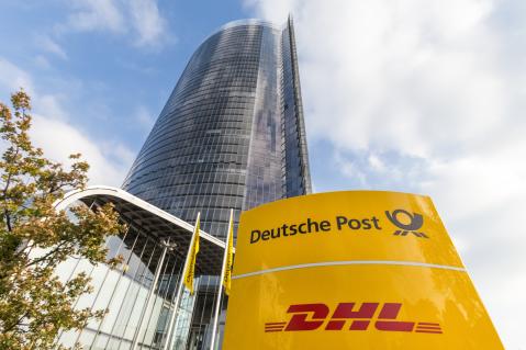 Postfiliale DHL Filiale Schild und riesen Postfiliale als Hochhaus im Hintergrund