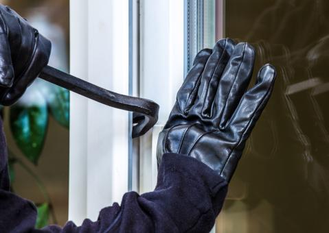 Nahaufnahme beim Einbrechen, Hand und Hebel an Fenster