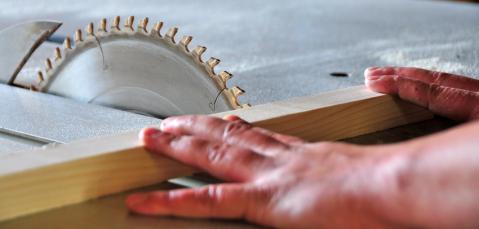 Nahaufnahme von Hand und Kreissäge zu Berufsunfähigkeitsversicherung