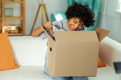 Mystery-Box Frau öffnet gespannt ein Paket